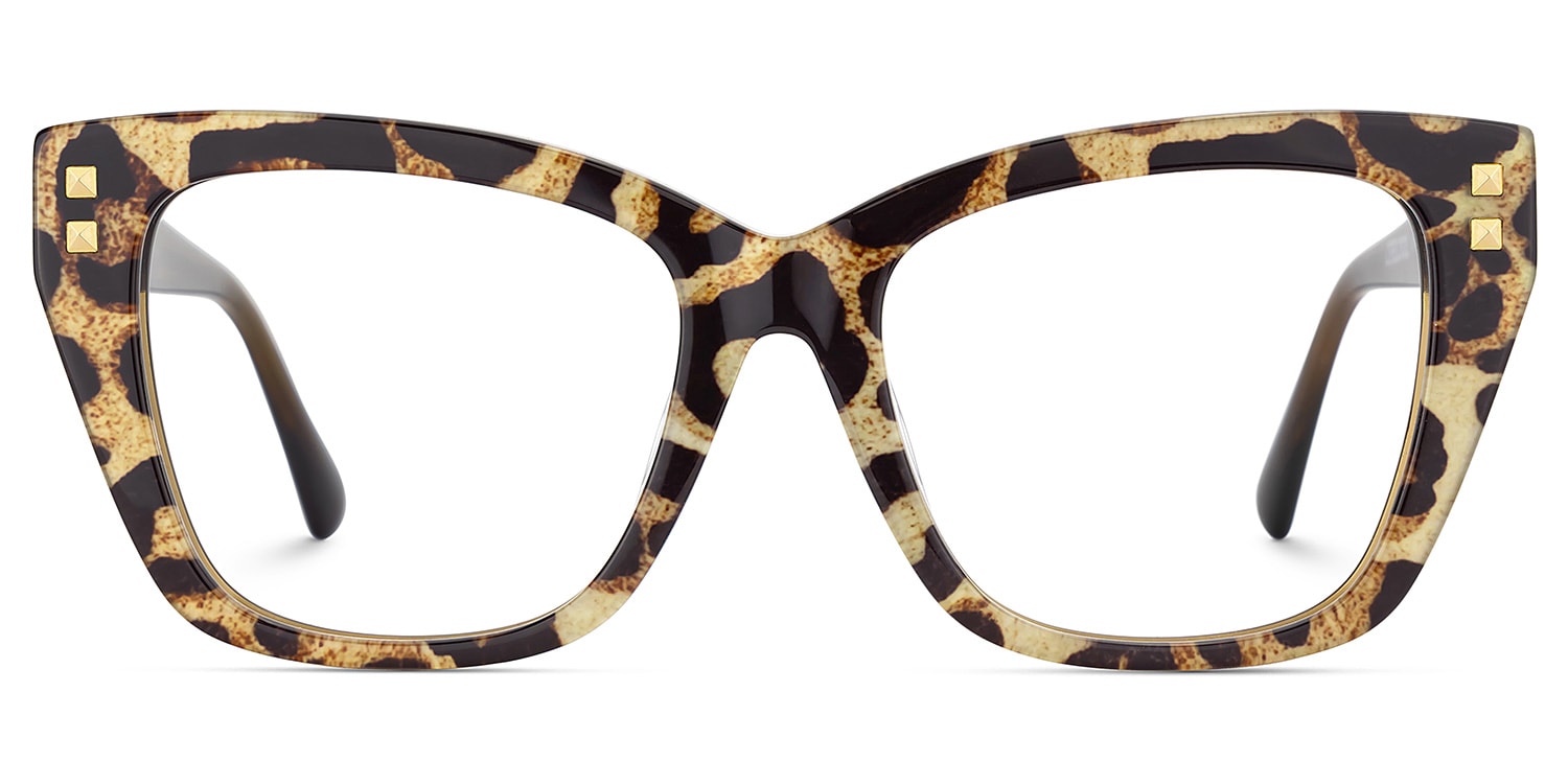 Lentes unisex tipo ojo de gato con acabado animal print en tonos café y beige, detalles metálicos dorados y varillas translúcidas. Diseño sofisticado, moderno y de inspiración fashion.