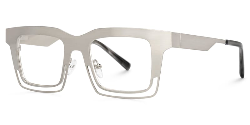 Lentes graduados cuadrados oversized en metal plata mate con diseño geométrico de líneas abiertas. Un armazón moderno, elegante y de inspiración vanguardista que combina ligereza visual y sofisticación.